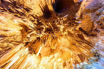 Up risen angle view of Stalactite stalactites with color lighting in cave
