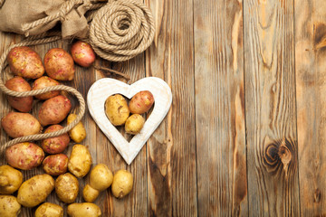 Potatoes and heart on a wooden background
