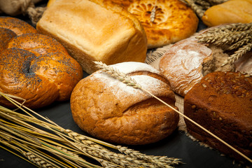 Assortment different types of bread. Rustic style bread on brown wooden table. Top view or flat lay. Copy space.