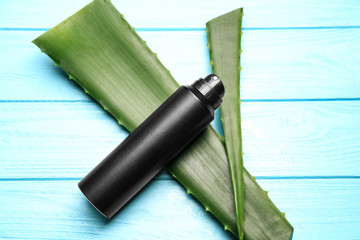 Deodorant for men and aloe on color wooden background