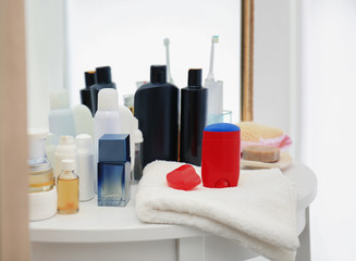 Deodorant for men and different hygiene items on shelf in bathroom