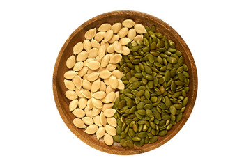 pumpkin seeds and peeled pumpkin seeds on the wood plate.