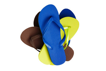 A stack of several pairs of multi-colored rubber flip-flops, iso