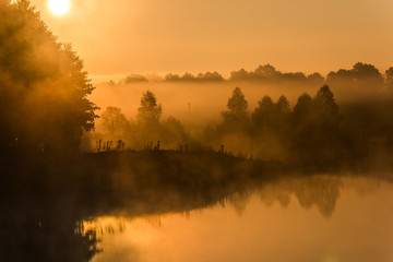 Sunrise over foggy lake at autumn