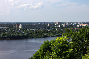 Fototapeta na wymiar View of the Oka river and the lower part of the city. Nature landscape, city, and house, barges and boats.