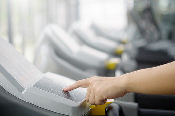 Hand pointing touch on screen treadmill with technology fitness sport concept.