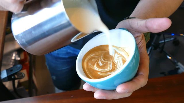 Barista making of cafe latte art, heart shape
