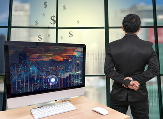 the computer on the wood table with trading graph at the screen in front of the glass window over on the trading graph over the blurred photo of cityscape,Back side of Businessman