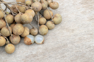 Longan Fresh. A bunch of Longan and Peel on a wooden background with green natural background in...