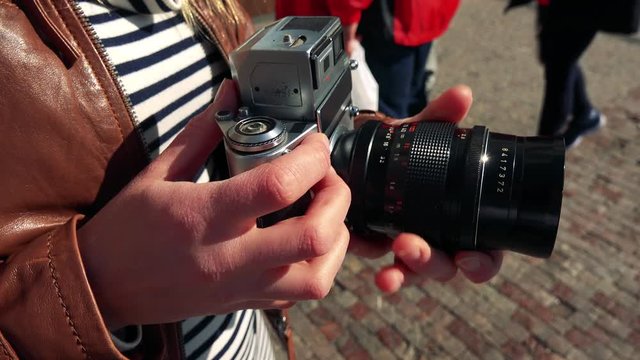 Closeup on a camera in a woman's hands in a street
