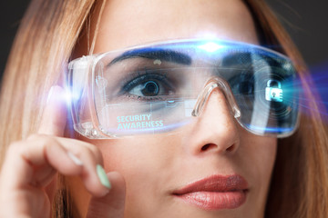 Business, Technology, Internet and network concept. Technology future. Young businesswoman working in virtual glasses, select the icon Security Awareness on the virtual display