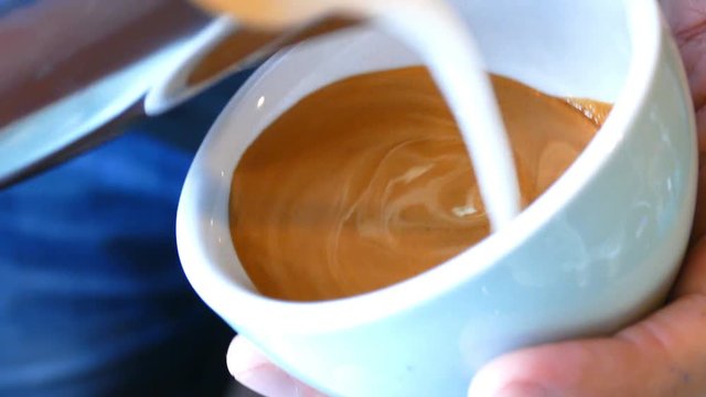 Barista making of cafe latte art, heart shape

