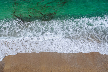 The aerial view of the sea water and the beach in summer