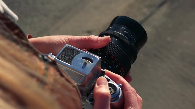 A woman uses zoom on a camera - closeup form above