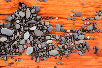 Pebbles on red log