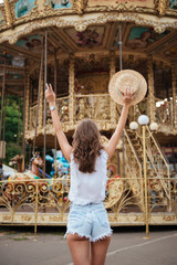 Back view portrait of a girl standing with outstretched hands