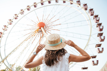 Back view of a young girl in hat standing