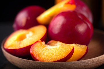 The red cut fruit on a wooden dish