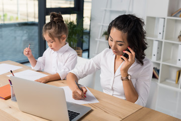 asian businesswoman with daughter in office