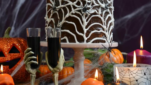 Spooky Halloween Party Table with chocolate spider cake, close up pan up handheld.