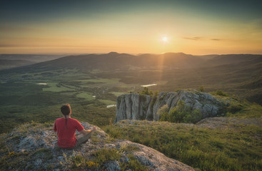 Fototapeta premium Tourist sitting on a rocky hill