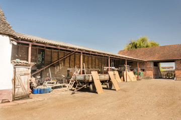 Household in the village with stables and tractors in the yard