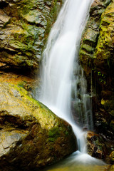 Fototapeta na wymiar A telephoto of an isolated waterfall in Transylvania, Romania