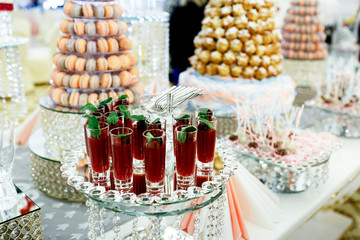 Tall glasses with red berry drinks stand on mirror tray