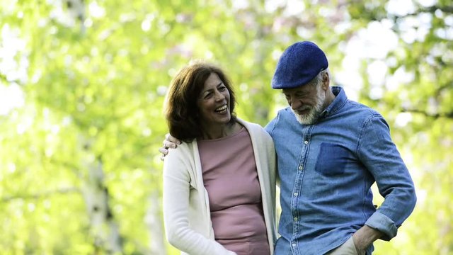 Beautiful senior couple in love outside in spring nature lauging.