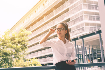 Fototapeta premium Asian businesswoman holding tablet computer at office outdoor.