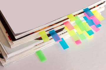 many colorful bookmarks in a magazine with the shallow depth of scene - obrazy, fototapety, plakaty