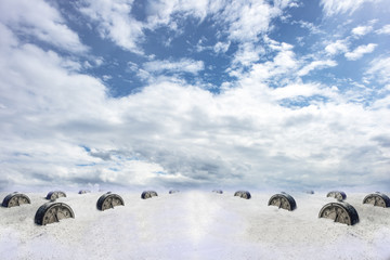 Abstraction: an old alarm clock on white sand under a blue sky