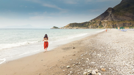 Obraz premium Young woman walking alone in barefoot at the shore