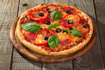 Delicious pizza served on wooden plate 