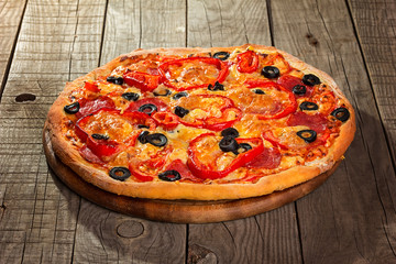 Delicious pizza served on wooden plate 