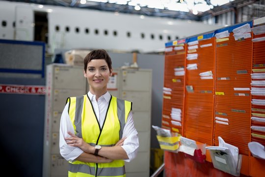 Female aircraft maintenance engineer standing with arms crossed