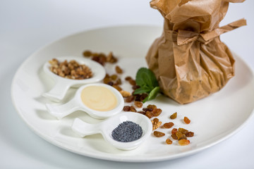 Sweet pasta en papillote with poppy seeds, raisins and walnuts on white background