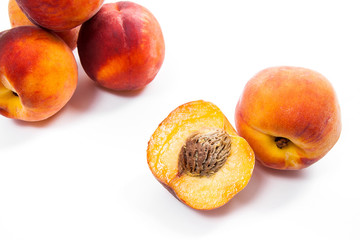 Group of ripe peach fruit and a half isolated on white background.