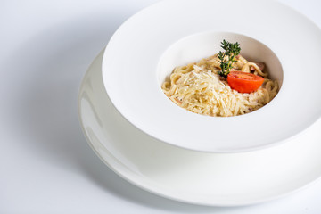 Spaghetti with tomato and cheese on white plate on white background