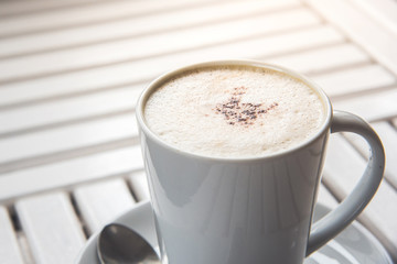 Cup of cappuccino on the table, coffee shop background.