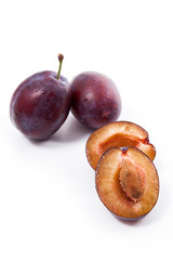 Group of whole and half of ripe plums isolated on a white background..