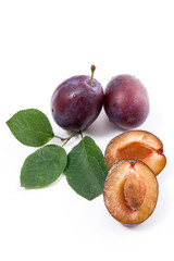 Group of whole and half of ripe plums with leaf isolated on a white background..