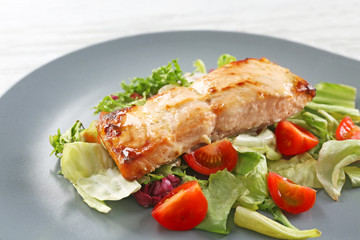 Plate with delicious salmon and salad, closeup