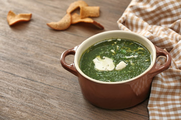 Casserole with fresh kale soup on table