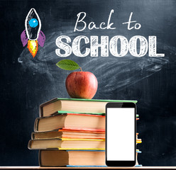 Back to School. Smartphone, books and fresh apple against blackboard