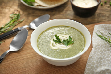 Bowl with fresh kale soup on table