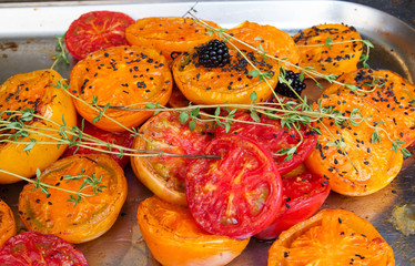 Red and yellow grilled tomatoes with thyme and blackberries