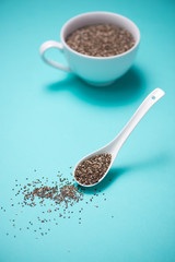 Cup of healthy chia seeds and spoon. Text space.