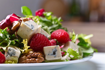 Green salad with blue cheese , raspberry and nuts