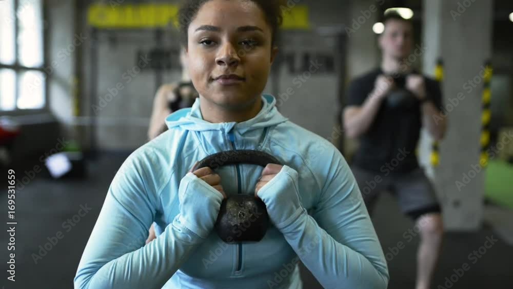 Canvas Prints Young people in crossfit gym doing squats with kettlebells